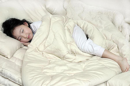 Happy Child on a Comforter Thanks to E-1 Environmental Standards